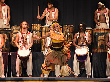 A student performs an African dance during a performance
